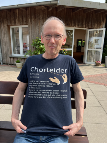 Eggo zeigt ein T-Shirt mit der Aufschrift"Der Chorleider"